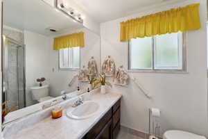 Bathroom with vanity, tile patterned floors, toilet, and a shower stall
