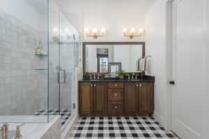 Bathroom with double vanity, a sink, and a shower stall