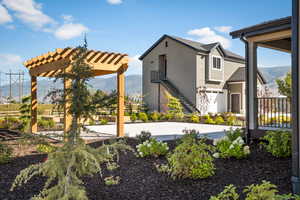 Exterior space featuring a pergola, a mountain view, stairs, and stucco siding