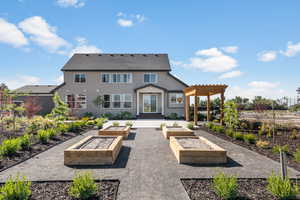 Rear view of property with a pergola, stucco siding, and a garden