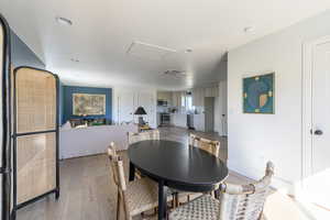 Dining space with attic access, recessed lighting, light wood-style flooring, and visible vents