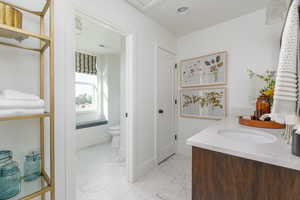 Bathroom with baseboards, visible vents, toilet, and marble finish floor