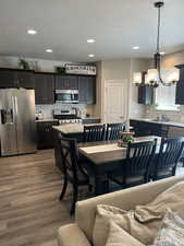 Dining area featuring recessed lighting, a notable chandelier, and wood finished floors