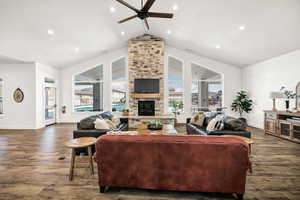 Living room featuring baseboards, a ceiling fan, dark wood-style flooring, and lofted ceiling