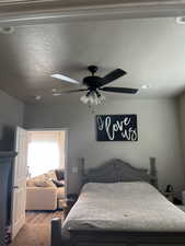 Bedroom featuring a textured ceiling, ceiling fan, and wood finished floors