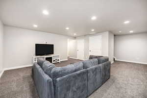 Carpeted living room with recessed lighting and baseboards