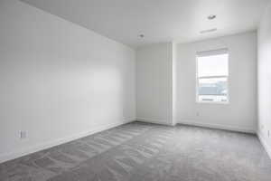 Unfurnished room featuring carpet floors, baseboards, recessed lighting, and visible vents