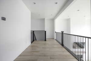 Corridor featuring recessed lighting, light wood-type flooring, and an upstairs landing