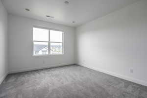 Spare room featuring baseboards, carpet, and visible vents