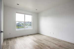 Empty room featuring baseboards and light wood-style flooring