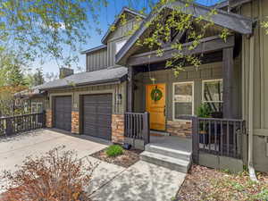 Craftsman house with an attached garage, board and batten siding, stone siding, and concrete driveway