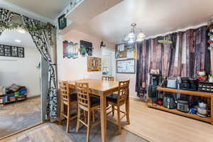 Dining area featuring baseboards, an inviting chandelier, and wood finished floors
