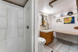 Full bathroom with vanity, walk in shower, tile patterned floors, and toilet