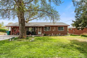 Ranch-style home with brick siding, a shingled roof, and a front lawn