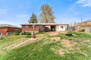 Rear view of house with a yard, a chimney, a fenced backyard, and central AC unit