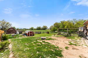 View of yard featuring fence, an outdoor structure, and a shed