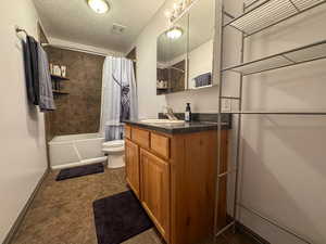 Bathroom featuring visible vents, vanity, toilet, a textured ceiling, and shower / tub combo