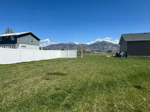 View of yard with a mountain view and fence