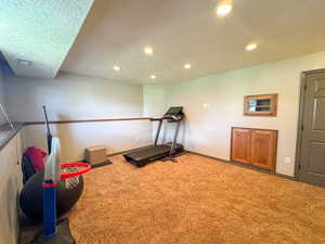 Workout area featuring baseboards, carpet, recessed lighting, and a textured ceiling