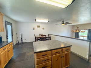 Kitchen featuring dark countertops, a center island, and a textured ceiling