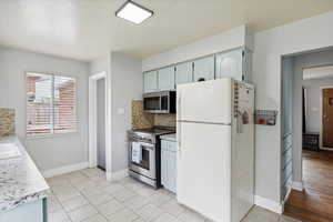 Kitchen with light countertops, decorative backsplash, and stainless steel appliances