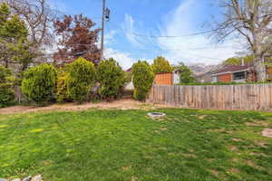 View of yard with fence and a fire pit
