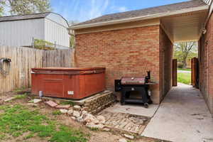 View of patio / terrace with fence and a hot tub