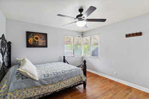Bedroom with baseboards, ceiling fan, and wood finished floors