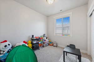 Recreation room with carpet floors, baseboards, and visible vents