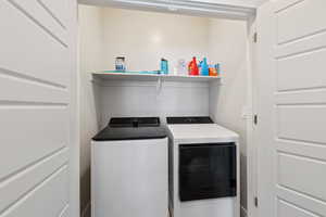 Washroom featuring laundry area and washer and clothes dryer