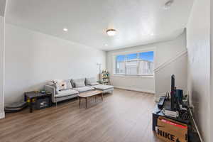 Living room with baseboards, recessed lighting, and wood finished floors