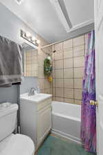 Full bathroom with toilet, shower / bath combo with shower curtain, and vanity