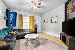 Living area featuring baseboards, ceiling fan, and wood finished floors