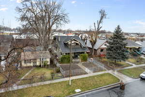 View of front of house with a shingled roof, fence, a front yard, and a residential view