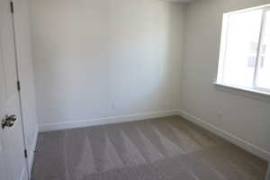 Unfurnished room with baseboards and carpet flooring