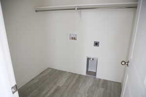 Washroom featuring washer hookup, hookup for an electric dryer, laundry area, wood finished floors, and baseboards