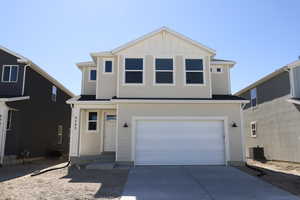 Traditional-style house featuring central AC unit, a garage, and concrete driveway
