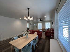 Dining area featuring baseboards, ceiling fan with notable chandelier, recessed lighting, and dark wood-type flooring