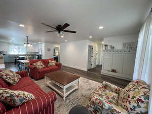Living area with recessed lighting, baseboards, ceiling fan with notable chandelier, and wood finished floors