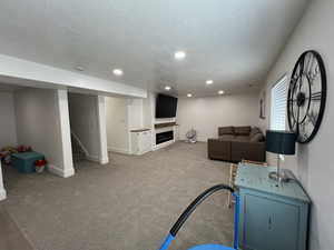 Living area with recessed lighting, a textured ceiling, baseboards, and stairway