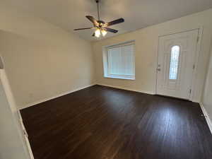 Foyer featuring baseboards, a ceiling fan, dark wood-style flooring, and vaulted ceiling