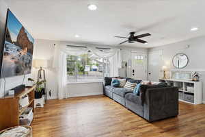 Living room with baseboards, a ceiling fan, recessed lighting, and wood finished floors