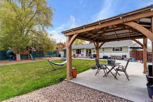 View of patio / terrace with fence, central AC unit, a gazebo, and a playground