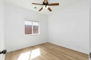 Empty room featuring baseboards, ceiling fan, and light wood-style flooring