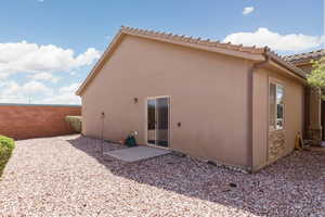 Back of property featuring fence, stucco siding, and a tiled roof