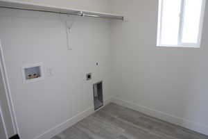 Laundry area featuring laundry area, washer hookup, baseboards, wood finished floors, and hookup for an electric dryer