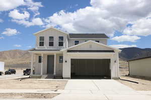 View of front of home with a shingled roof, a mountain view, board and batten siding, and concrete driveway
