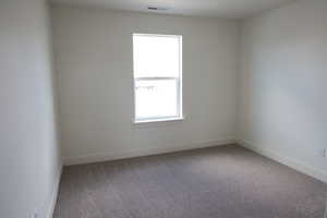 Unfurnished room with visible vents, carpet flooring, and baseboards