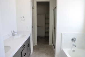 Full bath with double vanity, a stall shower, a sink, a closet, and a tub to relax in