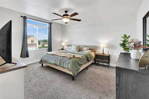 Carpeted bedroom featuring baseboards and ceiling fan